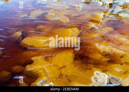 Nahaufnahme des orange roten Flusses mit Eisenerz und Kupfererzlagerstätten im Bergbaugebiet Rio Tinto Stockfoto