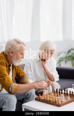 Ältere Paare spielen Schach auf der Couch im Wohnzimmer Stockfoto