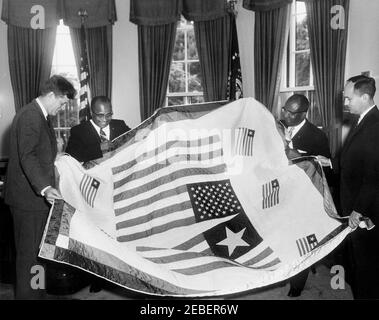 Treffen mit William R. Tolbert, Jr., Vizepräsident von Liberia, 11:36am Uhr. Präsident John F. Kennedy trifft den Vizepräsidenten von Liberia William R. Tolbert. (L-R) Präsident Kennedy, Vizepräsident Tolbert, der liberianische Botschafter George Padmore und der stellvertretende Direktor des Büros für westafrikanische Angelegenheiten Wendell B. Coote halten eine gesteppte Decke, die mit der liberianischen und amerikanischen Flagge geschmückt ist. Stockfoto