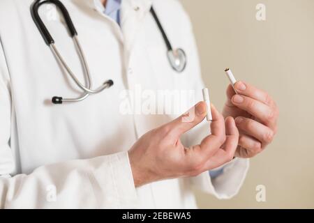 Bild von männlichen Arzt zeigt gebrochene Zigarette. Rauchen aufhören Konzept. Stockfoto
