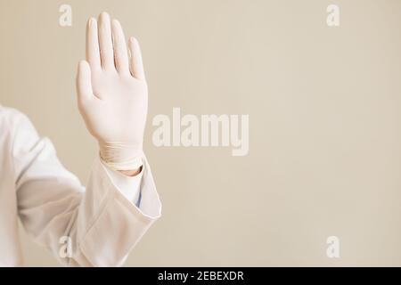 Bild der Nahaufnahme der Hand im Schutzhandschuh des Arztes mit Stoppschild. Stockfoto