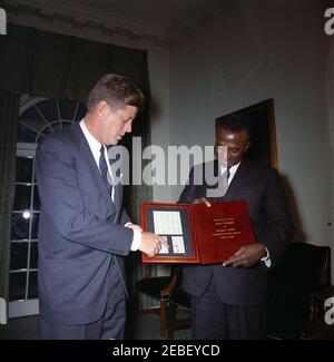 Treffen mit Sylvanus Olympio, Präsident von Togo, 2:53pm Uhr. Präsident von Togo, Sylvanus Olympio (rechts), überreicht Präsident John F. Kennedy einen Satz togolesischer Briefmarken zu Ehren der Astronauten John H. Glenn, Jr. und Alan B. Shepard, Jr. Kabinettsaal, Weisses Haus, Washington, D.C. [siehe auch MO 63,3248, u201cStamps zu Ehren der Astronauten Glenn und Shepardu201d] Stockfoto