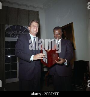 Treffen mit Sylvanus Olympio, Präsident von Togo, 2:53pm Uhr. Präsident von Togo, Sylvanus Olympio (rechts), überreicht Präsident John F. Kennedy einen Satz togolesischer Briefmarken zu Ehren der Astronauten John H. Glenn, Jr. und Alan B. Shepard, Jr. Kabinettsaal, Weisses Haus, Washington, D.C. [siehe auch MO 63,3248, u201cStamps zu Ehren der Astronauten Glenn und Shepardu201d] Stockfoto