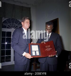 Treffen mit Sylvanus Olympio, Präsident von Togo, 2:53pm Uhr. Präsident von Togo, Sylvanus Olympio (rechts), überreicht Präsident John F. Kennedy einen Satz togolesischer Briefmarken zu Ehren der Astronauten John H. Glenn, Jr. und Alan B. Shepard, Jr. Kabinettsaal, Weisses Haus, Washington, D.C. [siehe auch MO 63,3248, u201cStamps zu Ehren der Astronauten Glenn und Shepardu201d] Stockfoto