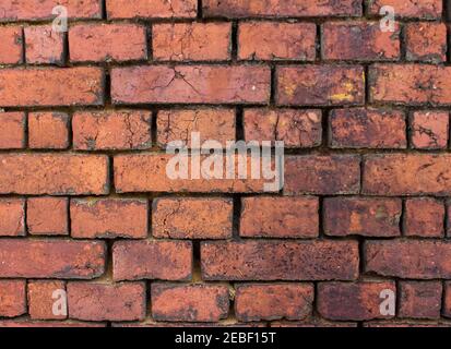 Alte rustikale detaillierte Ziegelwand in orange roten Farbtönen Hintergrund Stockfoto