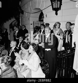 Abendessen zu Ehren von Habib Bourguiba, Sr., Präsident von Tunesien, 8:00pm Uhr. Gäste des Weißen Hauses Dinner zu Ehren von Habib Bourguiba, Sr., Präsident von Tunesien, versammelten sich in South Portico, um eine musikalische militärische Rezension auf dem South Lawn zu sehen. Zuerst Ladyu2019s Sozialsekretärin, Letitia Baldrige, steht hinten rechts; Verwalter des Bundesluftfahrtamtes, Najeeb Halaby, steht hinten im Zentrum; andere nicht identifiziert. White House, Washington, D.C. Stockfoto