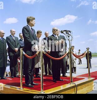 Ankunftzeremonien für Habib Bourguiba, Sr., Präsident von Tunesien, und Frau Moufida Bourguiba, 12:00pm Uhr. Ankunftszeremonien für Habib Bourguiba, Sr., Präsident von Tunesien; Präsident Bourguiba spricht in Mikrofone. Hinter Präsident Bourguiba, L-R: Staatssekretär für auswärtige Angelegenheiten Tunesiens, Dr. Sadok Mokaddem; Staatssekretär, Dean Rusk; Botschafter Tunesiens, Habib Bourguiba, Jr.; Präsident John F. Kennedy; Dolmetscher Charles Sedgwick; Protokollchef, Angier Biddle Duke. Der Geheimagent des Weißen Hauses, Gerald u201cJerryu201d Behn, steht rechts von der Plattform (rechts Stockfoto