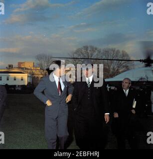 Begrüßungszeremonie für Vizepräsident Lyndon B. Johnson (LBJ) nach seiner Rückkehr aus Senegal, 5:55pm Uhr. Vizepräsident Lyndon B. Johnson geht mit Präsident John F. Kennedy nach der Rückkehr des Vizepräsidenten Presidentu2019s aus Senegal auf dem South Lawn, dem Weißen Haus, Washington D.C., folgt ein nicht identifizierter Mann. Stockfoto