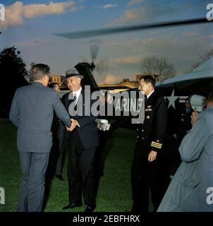 Begrüßungszeremonie für Vizepräsident Lyndon B. Johnson (LBJ) nach seiner Rückkehr aus Senegal, 5:55pm Uhr. Vizepräsident Lyndon B. Johnson begrüßt Präsident John F. Kennedy vor einem Hubschrauber des United States Marine Corps nach der Rückkehr des Vice Presidentu2019s aus Senegal auf dem South Lawn, dem Weißen Haus, Washington D.C. (L-R) Präsident Kennedy (zurück zur Kamera); Militärhilfe an den Präsidenten Chester V. Clifton (teilweise verborgen); Vice President Johnson; nicht identifizierter Mann (meist versteckt); Naval Aide an den Präsidenten Tazewell Shepard, Jr.; Assistent der Air Force Aide an den Präsidenten Frank S. Evans (i Stockfoto