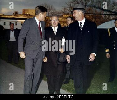 Begrüßungszeremonie für Vizepräsident Lyndon B. Johnson (LBJ) nach seiner Rückkehr aus Senegal, 5:55pm Uhr. Vizepräsident Lyndon B. Johnson geht mit Präsident John F. Kennedy nach der Vice Presidentu2019s Rückkehr aus Senegal auf dem South Lawn, White House, Washington D.C. (L-R) White House Media Network Elektriker, Cleve Ryan (im Hintergrund); Präsident Kennedy; nicht identifiziert; militärische Hilfe für den Präsidenten, Chester V. Clifton (teilweise versteckt); Vice President Johnson; Naval Aide to the President, Tazewell Shepard, Jr. (teilweise aus dem Rahmen). Stockfoto
