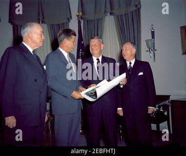 Treffen mit Mitgliedern der American Battle Monuments Commission (ABC), 12:17pm Uhr. Vertreter der American Battle Monuments Commission (ABC) präsentieren Präsident John F. Kennedy mit einem Foto des Manila American Cemetery and Memorial of Global City, Taguig, Phillippines, im Oval Office, White House, Washington, D.C. (L-R) ABC Vice Chairman Admiral Thomas Cassin Kinkaid; Präsident Kennedy; ABMC-Vorsitzender Jacob u0022Jakeu0022 Loucks Devers; Senior Member von ABMC und ehemalige Senatssekretärin Leslie L. Biffle. Stockfoto