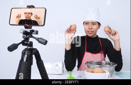 Food-Blogger. Asiatische Frau Koch Streaming live. Sie kommunizieren mit Abonnenten über Telefon-Kamera online. Vlogger und Online-Influencer Aufnahme Stockfoto