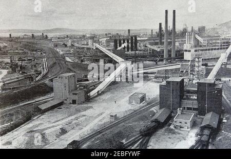 Ein frühes Pressefoto der Abbey Steel Works in Port Talbot, Wales, UK (Blast Furnesses im Hintergrund). Abbey Steelworks wurde 1947 geplant. Es wurde 1951 eröffnet und war bis 1953 voll funktionsfähig. Mehrere Stahlhersteller in Südwales kombinierten Ressourcen, um die Steel Company of Wales auf einem Gelände zu bilden, das damals Guest, Keen und Baldwins gehörte. Es wurde später verstaatlicht und in British Steel Corporation absorbiert, später immer noch Corus und dann Tata. Zur Zeit der Spitzenbeschäftigung im Jahr 1960s war das Abteiwerk Europas größtes Stahlwerk Stockfoto