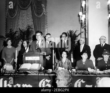 Bemerkungen beim Nationalen Gebetsfrühstück 1961, 9:37am Uhr. Gebetsfrühstück, das vom Internationalen Rat für christliche Führung im East Room, Mayflower Hotel, Washington, D.C. gesponsert wird, spricht Präsident John F. Kennedy die Frauen beim Gebetsfrühstück in einem separaten Raum des Hotels an. Ganz links ist der Co-Vorsitzende des Frühstücks Gladys Johnston (Ehefrau von Senator Olin Johnston aus South Carolina); rechts vom Präsidenten sind Vizepräsident Lyndon B. Johnson und Reverend Billy Graham; Lady Bird Johnson sitzt vor Reverend Graham; Gründer und Geschäftsführer von International Christian Lead Stockfoto