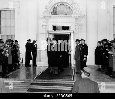 Zeremonien vor der Eröffnung im Weißen Haus. Der designierte Präsident John F. Kennedy (trägt den Hut) und Präsident Dwight D. Eisenhower gehen zur Eröffnungszeremonie, im Weißen Haus, Washington, D.C., Senator John J. Sparkman von Alabama steht hinter Präsident Eisenhower. Der Polizist des Weißen Hauses, Major Ralph C. Stover, und der Türsteher des Weißen Hauses, Preston Bruce, stehen links vom Eingang. Stockfoto