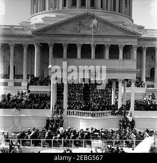 Eröffnungszeremonien im US-Kapitol und Eröffnungsparade. Einweihung von John F. Kennedy im East Portico, Kapitolgebäude der Vereinigten Staaten, Washington, D.C. Präsident John F. Kennedy hält Antrittsrede. Blick auf: Vizepräsident Lyndon B. Johnson; ehemaliger Vizepräsident Richard M. Nixon; ehemaliger Präsident Harry S. Truman; ehemalige First Lady Bess Truman; ehemaliger Präsident Dwight D. Eisenhower; ehemalige First Lady Mamie Eisenhower; First Lady Jacqueline Kennedy; Lady Bird Johnson; Joseph P. Kennedy, Sr.; und Rose Fitzgerald Kennedy. United States Marine Band auf Plattform unter Antrittsstand. Stockfoto