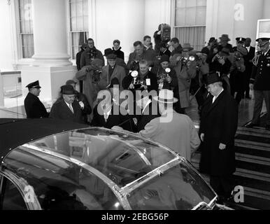 Zeremonien vor der Eröffnung im Weißen Haus. Vor der Antrittszeremonie verlassen das Weiße Haus, Washington, D.C., der designierte Präsident John F. Kennedy und Präsident Dwight D. Eisenhower das Weiße Haus für Antrittszeremonien. James J. Rowley, Geheimagent des Weißen Hauses, steht links vom designierten Präsidenten Kennedy; Senator John J. Sparkman von Alabama steht rechts vom Bild. Stockfoto