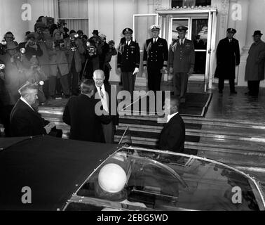 Zeremonien vor der Eröffnung im Weißen Haus. Zeremonien vor der Antrittsfeier, Weißes Haus, Washington, D.C. der designierte Präsident John F. Kennedy wird vor dem Weißen Haus von Präsident Dwight D. Eisenhower begrüßt. Senator John J. Sparkman aus Alabama steht ganz links. Militärhelfer von Präsident Eisenhower stehen auf den Stufen oben (L-R): Oberst des Militärdienstes Robert L. Schulz; Kapitän des Marineflugdienstes Evan P. Aurand und Oberst des Luftwaffenstützpunkts William G. Draper. Die Pressevertreter erfassen den Moment von links. Stockfoto