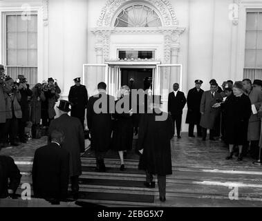 Zeremonien vor der Eröffnung im Weißen Haus. Vor der Eröffnungszeremonie kommen Vizepräsident Richard M. Nixon und seine Frau Pat Nixon im Weißen Haus an. Der Polizeichef des Weißen Hauses, Major Ralph C. Stover, steht links von der Tür; der designierte Präsident John F. Kennedyu0027s, Pressesprecher Pierre Salinger, steht rechts neben Reportern. Stockfoto