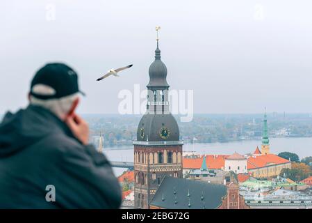 Ein Mann, Tourist in Point View, Panorama von Riga und Riga Kathedrale auf dem Dome-Platz während des Herbsttages, Lettland Stockfoto