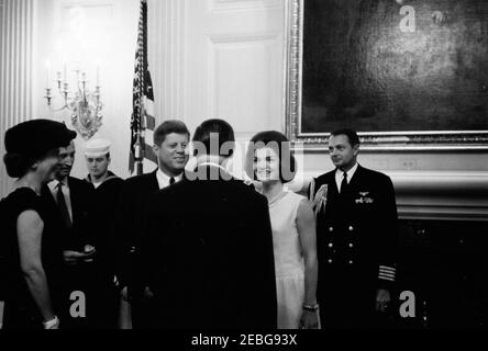 Diplomatischer Empfang, 6:00pm Uhr. Präsident John F. Kennedy und First Lady Jacqueline Kennedy begrüßen die Gäste in der Empfangslinie bei einem diplomatischen Empfang im Weißen Haus. Von links nach rechts: Nicht identifizierte Frau; Chef des Protokolls, Angier Biddle Duke; nicht identifizierte United States Navy Seemann; Präsident Kennedy; nicht identifizierter Mann; Mrs. Kennedy; Naval Aide to the President, Captain Tazewell Shepard. State Dining Room, White House, Washington, D.C. Stockfoto