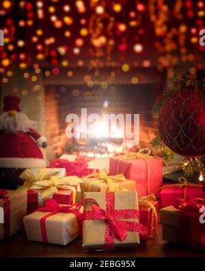 Xmas Innenraum Haus Feier Konzept. Weihnachtsgeschenke mit Bändern auf dem Boden, Santa Claus Puppe, Bokeh verwischen brennenden Kamin Hintergrund. Warme Familie Stockfoto