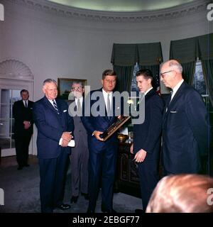 Besuch des Boysu0027 Clubsu0027 u0022Boy des Jahres,u0022 Stephen Lutz, 10:57AM. Präsident John F. Kennedy (Mitte) überreicht die Boysu0027 Clubs von Americau0027s (BCA) u0022Boy der Auszeichnung Yearu0022 an Stephen Lutz aus Newark, New Jersey. (L-R) nicht identifizierter Mann (hinten); Albert L. Cole, Präsident der BCA; John M. Gleason, Nationaldirektor der BCA; Präsident Kennedy; Stephen Lutz; und Charles R. Messier, Executive Director der Boysu0027 Clubs von Newark, New Jersey. Oval Office, White House, Washington, D.C. Stockfoto