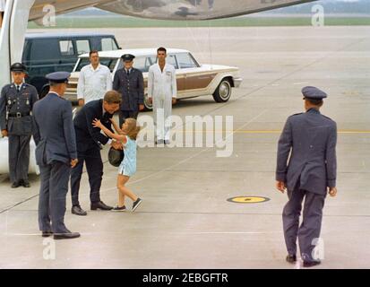 Wochenende im Hyannis Port: Präsident Kennedy mit Caroline Kennedy (CBK) und John F. Kennedy, Jr. (JFK Jr.), auf der Otis Air Force Base. Präsident John F. Kennedy (links, mit Hut) begrüßt seine Tochter Caroline Kennedy bei seiner Ankunft auf der Otis Air Force Base, Cape Cod, Massachusetts; United States Air Force Lieutenant Thomas O. Johnson steht in der Mitte der Gruppe vor dem Auto im Hintergrund. Alle anderen sind nicht identifiziert. Stockfoto