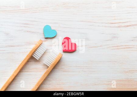 Zwei Bambus-Zahnbürsten, blaue und rote Holzherzen auf Vintage-Holz-Hintergrund. Biologisch abbaubare Bambus-Zahnbürsten. Naturprodukte. Umweltfreundlich, Null Stockfoto