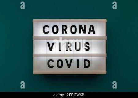 Leuchtkasten mit Inschrift Coronavirus covid auf dunkelgrünem Hintergrund. Wörter Coronavirus covid in Leuchtkasten. Coronavirus covid-19. Konzept von d Stockfoto