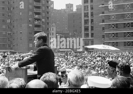 Reise nach New York City: International Ladies Garment Workers Union (ILGWU) Housing Project, 1:00pm Uhr. Präsident John F. Kennedy hält eine Rede bei der Einweihung der Penn Station South Cooperative Houses, einem kooperativen Wohnprojekt der International Ladiesu2019 Garment Workersu2019 Union (ILGWU). Ebenfalls im Bild: Ehemalige First Lady, Eleanor Roosevelt; Geheimagent des Weißen Hauses, Gerald A. u201cJerryu201d Behn. New York City, New York. Stockfoto