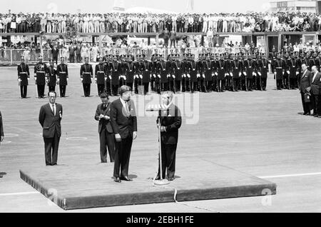 Reise nach Mexiko: Ankunftszeremonie, Internationaler Flughafen Mexiko-Stadt, Mexiko-Stadt, 11:00am Uhr. Der Präsident von Mexiko, Adolfo Lu00f3pez Mateos (AT Mikrofone), hält Begrüßungsworte bei der Ankunft von Präsident John F. Kennedy in Mexiko-Stadt. Der Dolmetscher des US-Außenministeriums, Donald Barnes (links), steht hinter der Plattform. Ebenfalls abgebildet: Sonderassistent des Präsidenten von Mexiko, Justo Sierra. Im Hintergrund stehen Mitglieder eines Ehrengardes. Internationaler Flughafen Benito Juu00e1rez, Mexiko-Stadt, Mexiko. Stockfoto