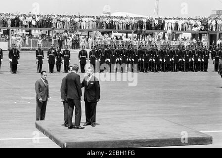 Reise nach Mexiko: Ankunftszeremonie, Internationaler Flughafen Mexiko-Stadt, Mexiko-Stadt, 11:00am Uhr. Präsident John F. Kennedy begrüßt den Präsidenten Mexikos, Adolfo Lu00f3pez Mateos (rechts), während einer Ankunftszeremonie in Mexiko-Stadt. Ebenfalls im Bild: Chef des Protokolls von Mexiko, Federico A. Mariscal, und US-Außenministerium Dolmetscher, Donald Barnes. Im Hintergrund stehen Mitglieder eines Ehrengardes. Internationaler Flughafen Benito Juu00e1rez, Mexiko-Stadt, Mexiko. Stockfoto