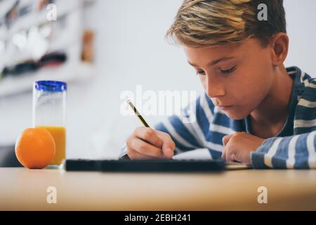 Student Zeichnung mit Bleistift auf dem Notizbuch. Junge macht Hausaufgaben Schreiben auf einem Papier. Kind halten Sie einen Bleistift und zeichnen Sie ein Manga zu Hause. Teen Zeichnung sitzen Stockfoto