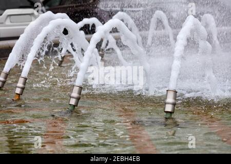 Die geschäumten Wasserstrahlen des Stadtbrunnens schaffen eine Extravaganz von Spritzern mit einem schönen Tanz. Stockfoto