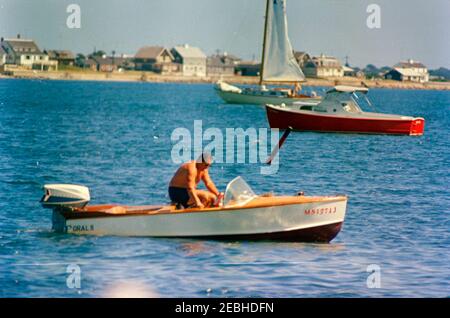 Labor Day Wochenende im Hyannis Hafen: Kennedy Familie und Freunde fahren an Bord der Honey Fitz, 11:47am Uhr. Ein nicht identifizierter Mann sitzt in einem Boot vor der Küste von Hyannis Port, Massachusetts, während des Labor Day Wochenendes. Stockfoto