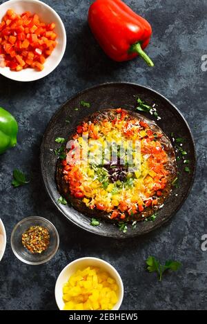 Regenbogen Veggie Paprika Pizzakruste auf blauem Steingrund. Vegetarisch vegan oder gesundes Essen Konzept. Draufsicht, flaches Lay Stockfoto