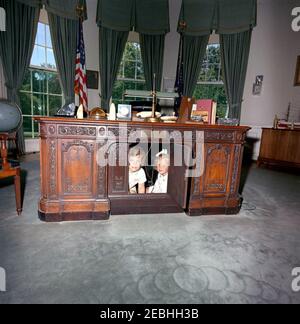 Caroline Kennedy (CBK) u0026 Kerry Kennedy im Oval Office. Caroline Kennedy und Kerry Kennedy, Tochter des Generalstaatsanwalts Robert F. Kennedy, schauen durch das klappbare Panel des Präsidenten John F. Kennedyu0027s-Schreibtisches (HMS Resolute Desk) im Oval Office, White House, Washington, D.C. Stockfoto