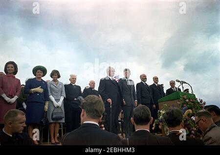 Europareise: Irland, New Ross. Präsident John F. Kennedy und andere angesehene Gäste nehmen an einer Begrüßungszeremonie für Präsident Kennedy am New Ross Quay in New Ross, County Wexford, Irland, Teil. Auf der Plattform speakersu0027 stehend, erste Reihe (L-R): Präsident Kennedyu0027s Schwägerin, Prinzessin Lee Radziwill von Polen; nicht identifiziert; die Schwester von Presidentu0027s, Jean Kennedy Smith; zwei nicht identifiziert; stellvertretender Vorsitzender des New Ross Urban District Council, Gerald Donovan; der Präsident; Vorsitzender des New Ross Urban District Council, Andrew Minihan; Minister für auswärtige Angelegenheiten Irlands, Fr. Stockfoto