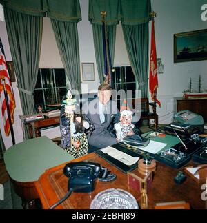 Präsident Kennedy mit Caroline Kennedy (CBK) u0026 John F. Kennedy, Jr. (JFK, Jr.), in Halloween-Kostümen. Präsident John F. Kennedy besucht mit seinen Kindern Caroline Kennedy (links mit Katze) und John F. Kennedy, Jr., im Oval Office; die Kinder tragen Halloween-Kostüme. White House, Washington, D.C. Stockfoto
