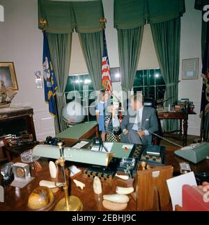Präsident Kennedy mit Caroline Kennedy (CBK) u0026 John F. Kennedy, Jr. (JFK, Jr.), in Halloween-Kostümen. Präsident John F. Kennedy besucht mit seiner Tochter Caroline Kennedy (telefonisch sprechend, in Halloween-Kostümen) und Nichte Maria Shriver im Oval Office des Weißen Hauses, Washington, D.C. Stockfoto