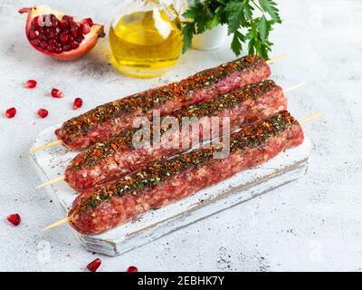 Rohes Rinderlamm lula Kebab auf Holzspieß auf einem Brett, Nahaufnahme Stockfoto