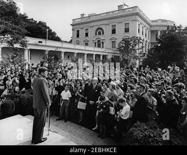 Besuch einer Gruppe von Fulbright-Hayes Exchange Lehrern, 9:45am Uhr. Präsident John F. Kennedy (links, an Mikrofonen) hält eine Gruppe von Lehrern, die am Fulbright-Hays-Austauschprogramm teilnehmen, und ihre Familien bei einem Besuch im Rosengarten des Weißen Hauses, Washington, D.C., Rede Stockfoto