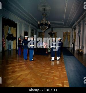 Staatsfuneral von Präsident Kennedy: In Ruhe im Ostraum des Weißen Hauses liegend. Der verstorbene Präsident John F. Kennedy liegt in Ruhe im Ostraum des Weißen Hauses; Präsident Kennedyu2019s mit Flagge drapierte Sarg sitzt in der Mitte. Mitglieder der Ehrenwache stehen Wache, darunter Leutnant William F. Lee. Washington, D.C. Stockfoto
