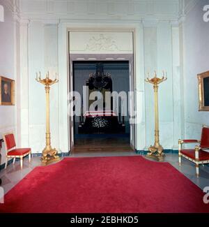 Staatsfuneral von Präsident Kennedy: In Ruhe im Ostraum des Weißen Hauses liegend. Präsident John F. Kennedyu2019s Fahnendrapierte Schatulle im Ostraum, von der Cross Hall aus gesehen, als der verstorbene Präsident in Ruhe liegt. White House, Washington, D.C. Stockfoto