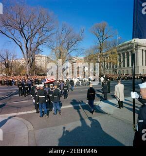 Staatsfuneral von Präsident Kennedy: Abfahrt vom Weißen Haus und Prozession zum Kapitol der Vereinigten Staaten. Die Schatulle von Präsident John F. Kennedy, die in einer Trauerprozession vom Weißen Haus zum Kapitolgebäude fährt, wird zur Pennsylvania Avenue. Die Fahnenschwärzette wird von einem Pferdekaisson mit Ehrengarde getragen. Washington, D.C. Stockfoto