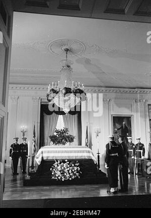 Staatsfuneral von Präsident Kennedy: In Ruhe im Ostraum des Weißen Hauses liegend. Der verstorbene Präsident John F. Kennedy liegt in Ruhe im Ostraum des Weißen Hauses; Präsident Kennedyu2019s mit Flagge drapierte Schatulle sitzt in der Mitte links. Die Mitglieder der Ehrenwache stehen Wache. Washington, D.C. Stockfoto