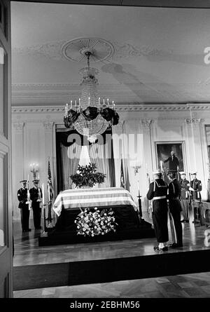 Staatsfuneral von Präsident Kennedy: In Ruhe im Ostraum des Weißen Hauses liegend. Der verstorbene Präsident John F. Kennedy liegt in Ruhe im Ostraum des Weißen Hauses; Präsident Kennedyu2019s mit Flagge drapierte Schatulle sitzt in der Mitte links. Die Mitglieder der Ehrenwache stehen Wache. Washington, D.C. Stockfoto