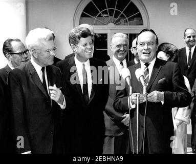 Übergabe einer Congressional Gold Medal an Bob Hope, 12:10pm. Präsident John F. Kennedy lacht als Schauspieler und Komiker, Bob Hope, hält Bemerkungen, nachdem er die Kongress-Goldmedaille erhalten hat, die Präsident Kennedy in Anerkennung seiner Verdienste um das Land als Entertainer während des Zweiten Weltkriegs überreicht hat Von links nach rechts: Senator Thomas H. Kuchel (Kalifornien); Repräsentant Michael A. Feighan (Ohio); Präsident Kennedy; Senator Stuart Symington (Missouri); Herr Hope; Dolores Hope (meist versteckt), Ehefrau von Herrn Hope; nicht identifizierter Mann. Rose Garden, White House, Washington, D.C. Stockfoto