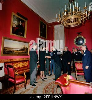 Staatsbegräbnis von Präsident Kennedy: Weißes Haus, nach Beerdigung Empfang. Jacqueline Kennedy und Senator Edward M. Kennedy (Massachusetts) begrüßen die Gäste bei einem Empfang im Weißen Haus nach dem Staatsbegräbnis von Präsident John F. Kennedy; Frau Kennedy schüttelt die Hände mit einem unbekannten Mann. Ebenfalls im Bild: Präsident des Senats von Australien, Sir Alister McMullin; Präsident des italienischen Senats, Cesare Merzagora; Minister für auswärtige Angelegenheiten Italiens, Attilio Piccioni; Botschafter Italiens, Sergio Fenoaltea; US-Chef des Protokolls, Angier Biddle Duke. Red Room, White House, Washington, Stockfoto